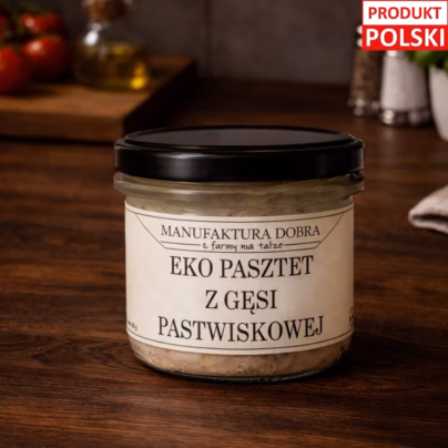 Pasztet z gęsi pastwiskowej w szklanym słoiku, ręcznie przygotowany w Manufakturze Dobra, na drewnianym tle z ziołami i drewnianą łyżką