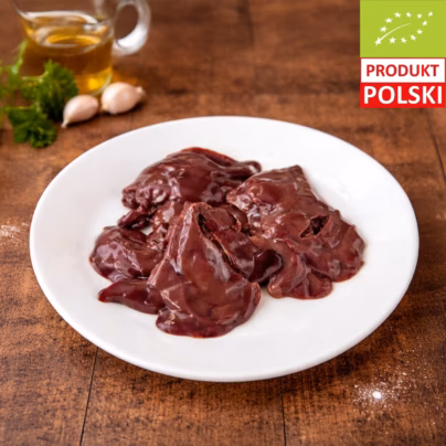 Wątróbka z kurczaka pastwiskowego — surowe podroby na białym talerzu z ząbkami czosnku, świeżą natką pietruszki i oliwą w tle