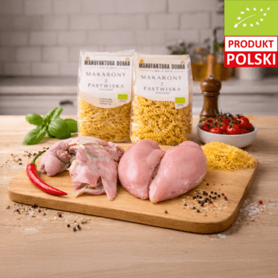 Mięsna paczka na rosół – porcja rosołowa i pierś z kurczaka na desce, w tle makaron durum nitki i świderki z Manufaktury Dobra.