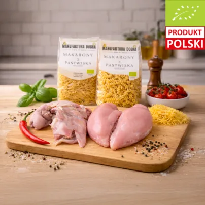 Mięsna paczka na rosół – porcja rosołowa i pierś z kurczaka na desce, w tle makaron durum nitki i świderki z Manufaktury Dobra.