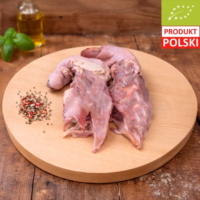Porcja rosołowa z kurczaka ekologicznego — surowe szyje i korpus kurczaka pastwiskowego ułożone na drewnianej desce z kolorowym pieprzem i świeżą bazylią
